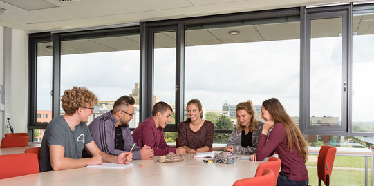 Lerngruppe Studierende sitzen mit Lernunterlagen am Tisch.